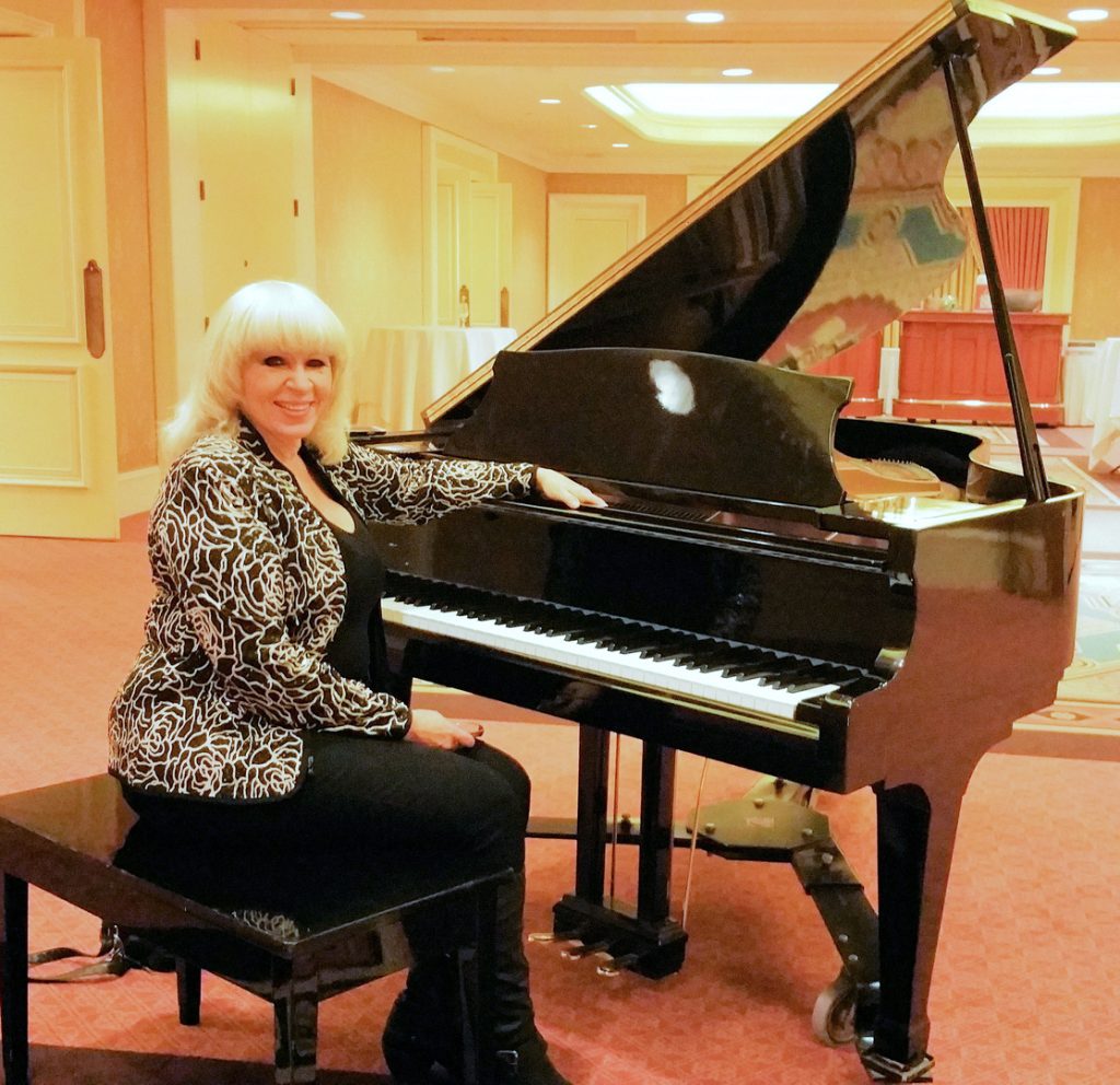 A woman sitting on top of a piano.