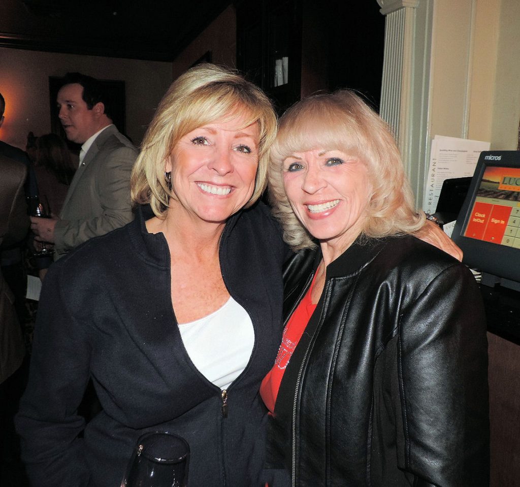 Two women posing for a picture at an event.