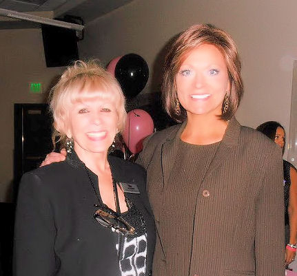 Two women posing for a picture at an event.